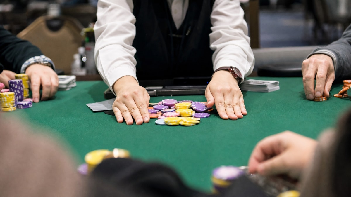Chips being pushed across a felt table during a busy WSOP tournament
