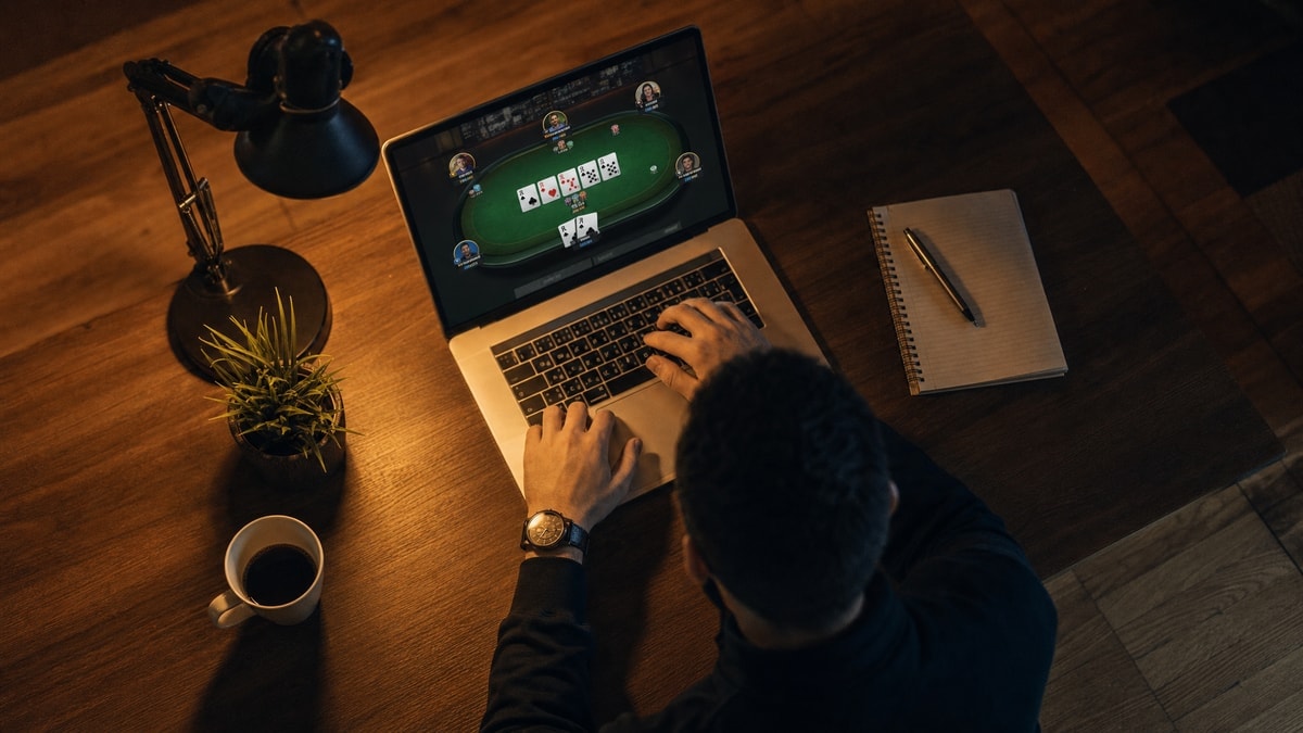 A grinder plays an online poker tournament on a laptop during a late-night Sunday session